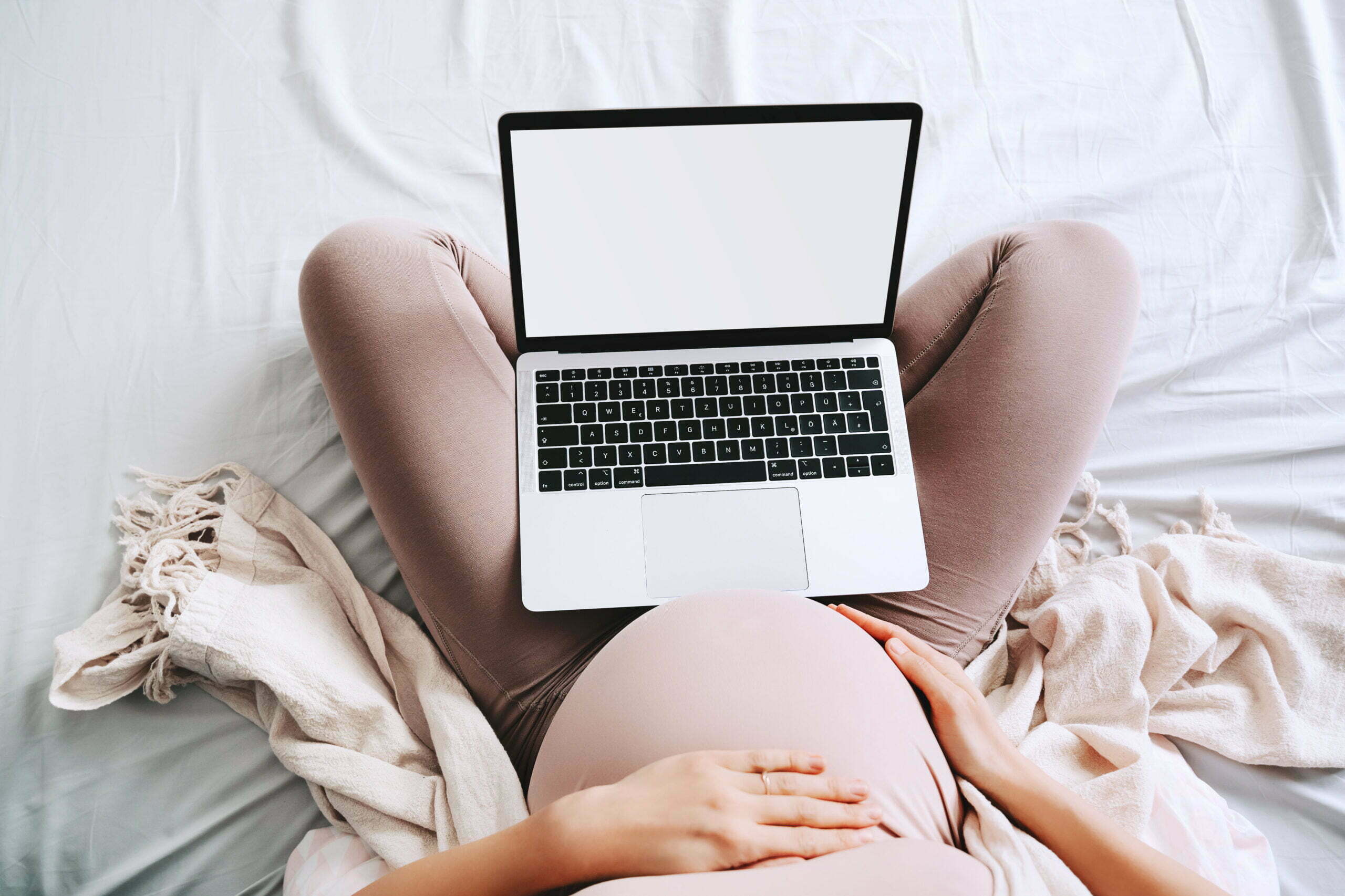 Pregnant,woman,using,laptop,at,home.,close up,pregnant,belly,of